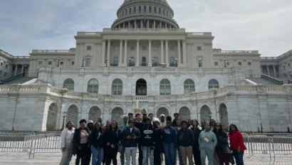 Students from our school group travel program pose for a photo in front of the U.S. Capitol building on a sunny day.
