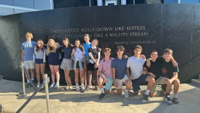 Group of young people standing in front of a wall with a Martin Luther King Jr. quote.