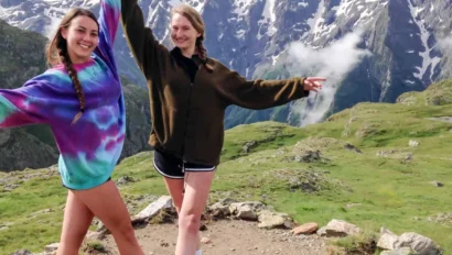 Two students posing by mountains.