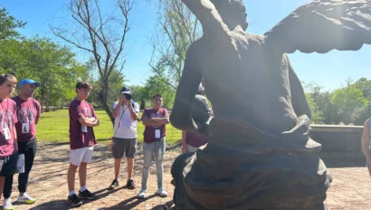A school group travel outing in the United States with students gathering to observe a statue.